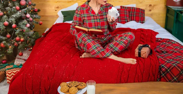 Christmas morning, girl in pajamas with a book. Selective focus. — Stock Photo, Image