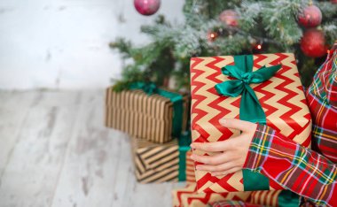 Noel sabahı, elinde hediyelerle bir kız. Seçici odak