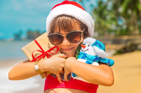 Een kind naar het beeld van de Kerstman op het strand. Selectieve focus. — Stockfoto