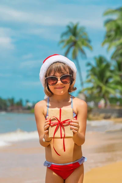 Uma criança à imagem do Pai Natal na praia. Foco seletivo . — Fotografia de Stock