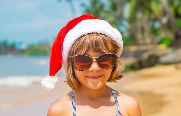 海滩上一个圣诞老人形象中的孩子。 有选择的重点. — 图库照片