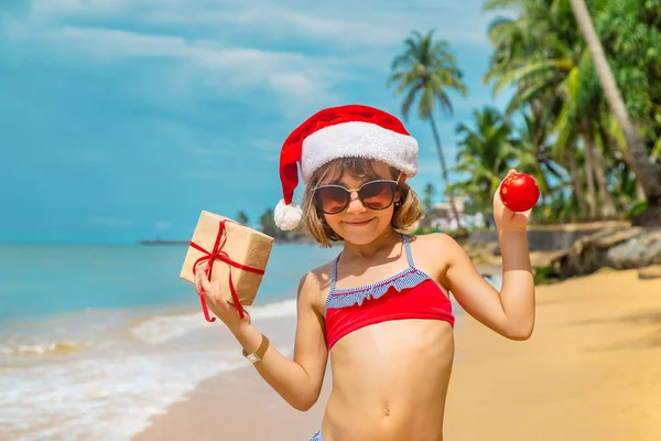海滩上一个圣诞老人形象中的孩子。 有选择的重点. — 图库照片