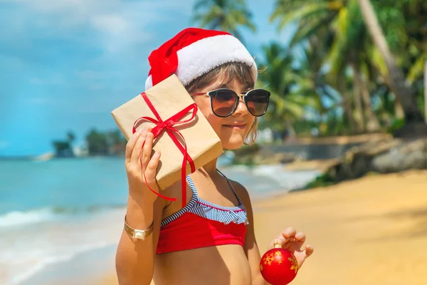 Een kind naar het beeld van de Kerstman op het strand. Selectieve focus. — Stockfoto