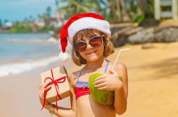 Ein Kind im Bild des Weihnachtsmannes am Strand. Selektiver Fokus. — Stockfoto