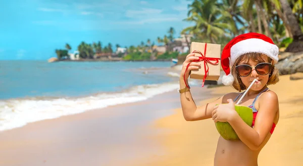 Ein Kind im Bild des Weihnachtsmannes am Strand. Selektiver Fokus. — Stockfoto