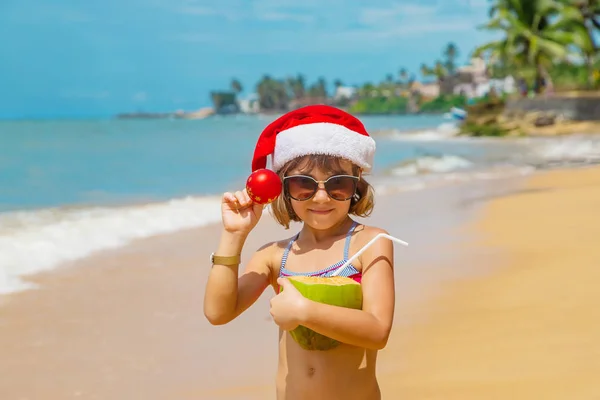 Een kind naar het beeld van de Kerstman op het strand. Selectieve focus. — Stockfoto