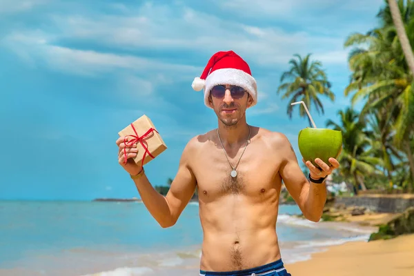 Um homem à imagem do Pai Natal na praia. Foco seletivo . — Fotografia de Stock