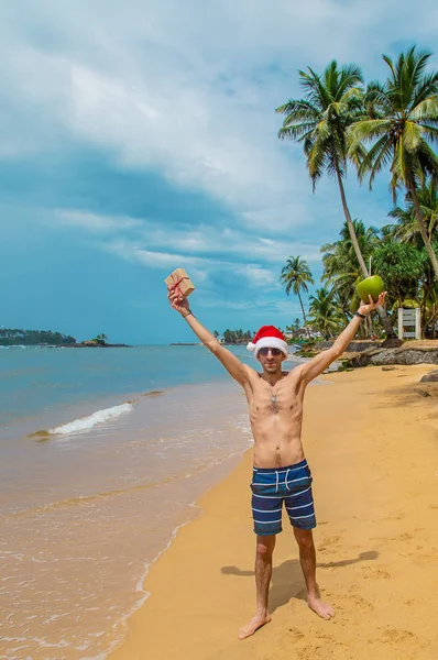 Um homem à imagem do Pai Natal na praia. Foco seletivo . — Fotografia de Stock