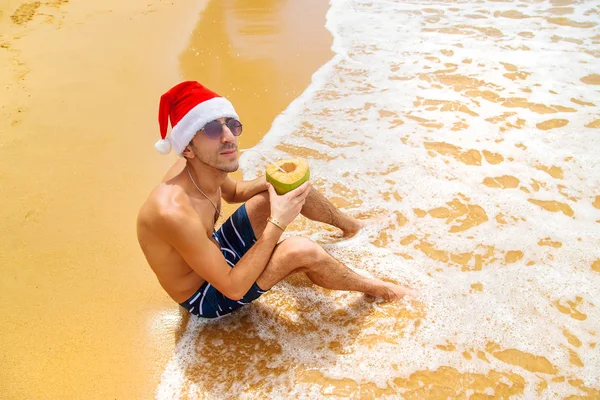 Um homem à imagem do Pai Natal na praia. Foco seletivo . — Fotografia de Stock