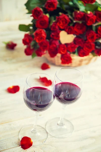 Un ramo de rosas rojas y vino tinto en copas. Día de San Valentín. Enfoque selectivo . —  Fotos de Stock