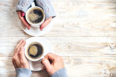 Aşıkların elinde kahvaltı için bir bardak içki. Seçici odak.