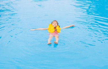 Çocuk yaz aylarında havuzda yüzer. Seçici odak.