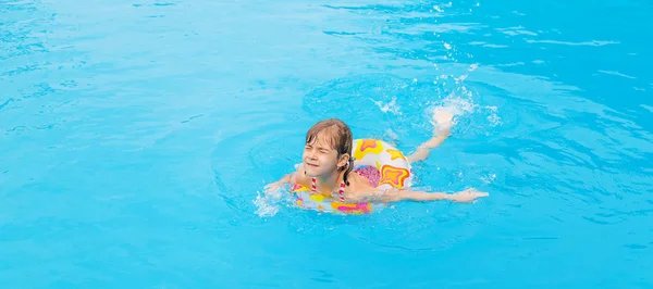Het kind zwemt in de zomer in het zwembad. Selectieve focus. — Stockfoto