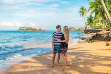 Kız ve adam sahilde, okyanusun kenarında. Seçici odak.