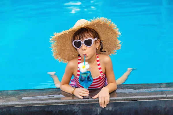 Un enfant près de la piscine boit un cocktail. Concentration sélective. — Photo