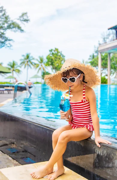 Un niño cerca de la piscina bebe un cóctel. Enfoque selectivo. — Foto de Stock