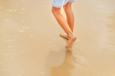 Sahilde koşan bir çocuğun ayakları. Seçici odak.