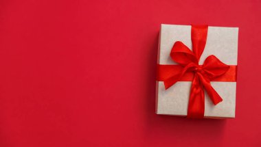 Kırmızı arka planda bir hediye. Seçici odak.