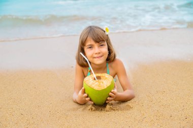 Sahilde hindistan cevizi içen bir çocuk. Seçici odak.