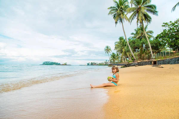 Uma criança na praia bebe coco. Foco seletivo . — Fotografia de Stock