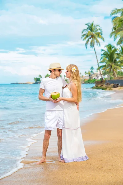 Um homem e uma rapariga na praia estão a beber coco. Foco seletivo . — Fotografia de Stock