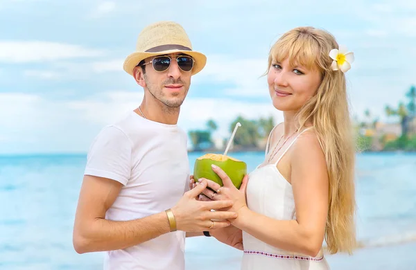 Muž a dívka na pláži popíjejí kokos. Selektivní zaměření. — Stock fotografie