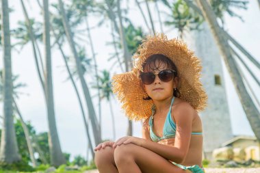 Sri Lanka 'da deniz feneri olan bir adada bir çocuk. Seçici odak.
