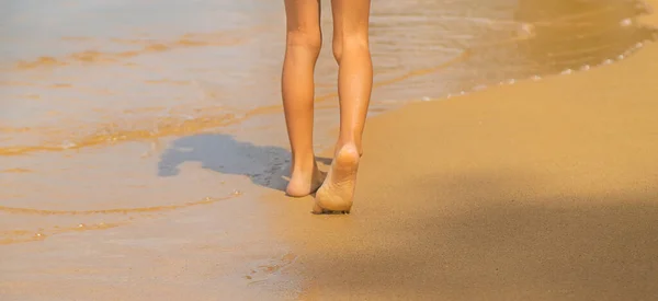 Egy gyerek lábai futkároznak a parton. Szelektív fókusz. — Stock Fotó