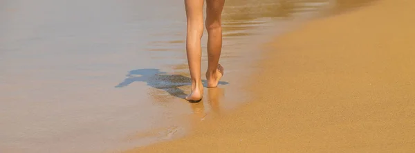 Pés de uma criança correndo ao longo da praia. Foco seletivo . — Fotografia de Stock