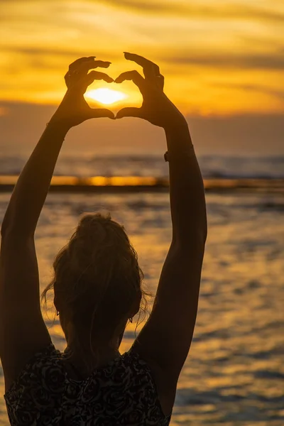 A rapariga faz mãos de coração ao pôr-do-sol. Sri Lanka. Foco seletivo . — Fotografia de Stock