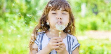 Dandelions hava üfleme kız. seçici odak.