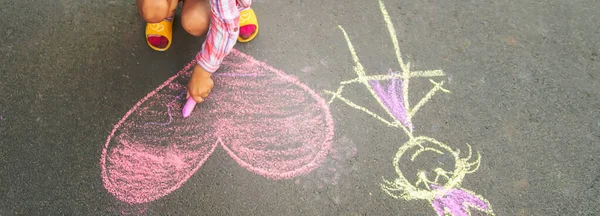 Dziecko maluje kredą na asfalcie serce. Selektywny fokus. — Zdjęcie stockowe