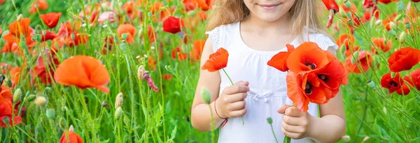 Fille d'enfants dans un champ avec des coquelicots. focus sélectif . — Photo