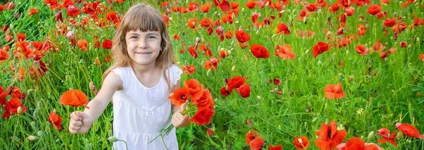 Fille d'enfants dans un champ avec des coquelicots. focus sélectif . — Photo