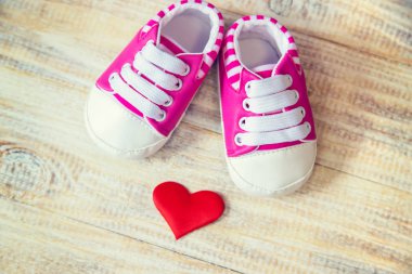 Hafif arka planda bebek poposu ve kalp. Seçici odak.