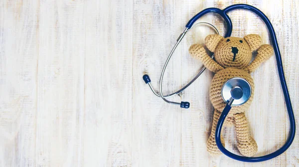 Children's toy and a stethoscope on a light background. Selective focus. — Stock Photo, Image