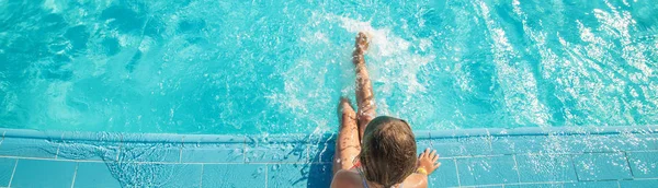 A criança nada e mergulha na piscina. Foco seletivo. — Fotografia de Stock