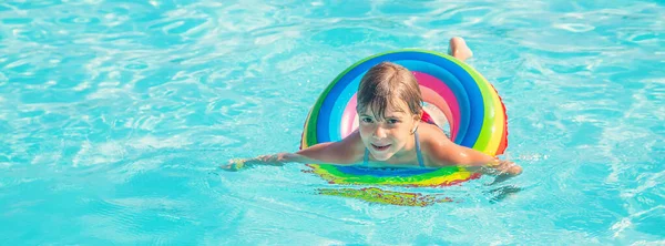 Ребенок плавает и ныряет в бассейн. Селективный фокус. — стоковое фото