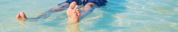 Un hombre nada en el mar acostado boca arriba. Enfoque selectivo . —  Fotos de Stock