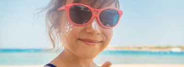 Bir çocuğun teninde güneş kremi. Seçici odak.