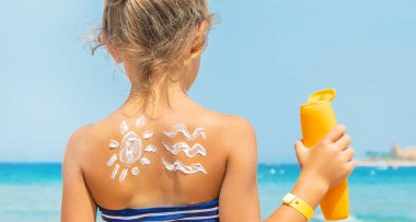 Bir çocuğun teninde güneş kremi. Seçici odaklanma. Doğa.