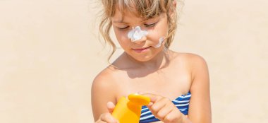 Bir çocuğun teninde güneş kremi. Seçici odak.