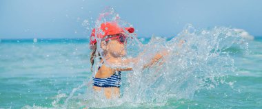 çocuk denize sprey yapar. Seçici odaklama.