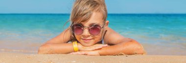 çocuk sahilde kum yatıyor. Seçici odaklama.