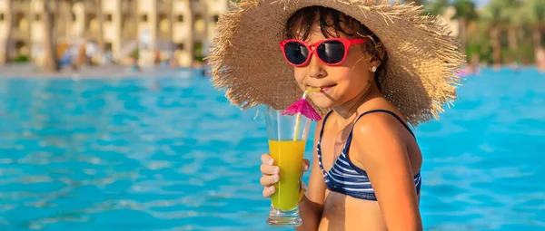 A child at the sea drinks a cocktail. Selective focus.