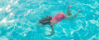 çocuk yüzer ve havuza dalın. Seçici odak. Doğa.