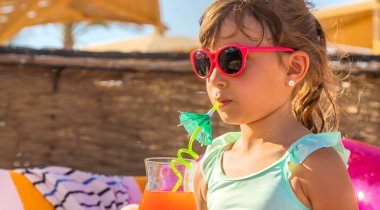 Denizde bir çocuk kokteyl içer. Seçici odak.