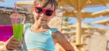 Denizde bir çocuk kokteyl içer. Seçici odak.