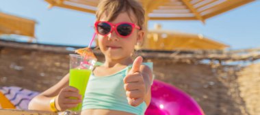 Denizde bir çocuk kokteyl içer. Seçici odak.