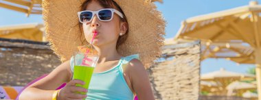 Denizde bir çocuk kokteyl içer. Seçici odak.